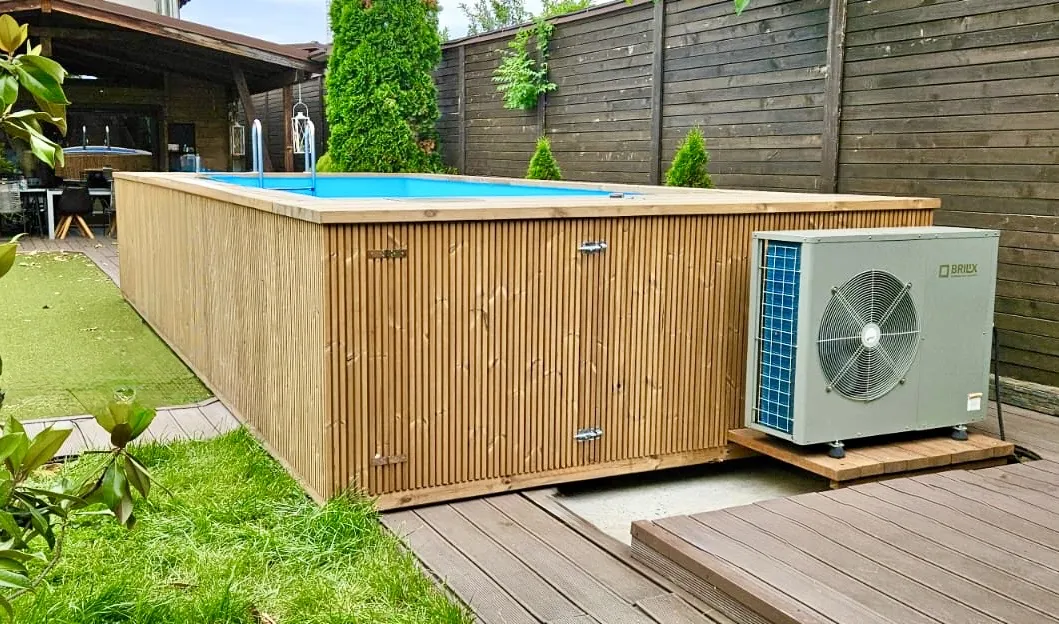 Rechteckiger Holzpool mit blauem Wasser, daneben Wärmepumpe, Gartenumgebung